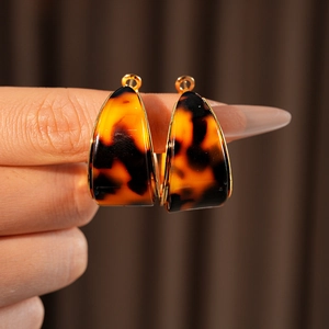 Detailed close-up of amber resin hoop earrings with gold-plated metallic borders