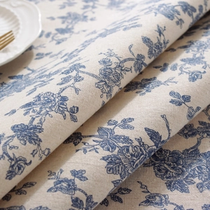 Detailed macro shot of blue floral cotton linen tablecloth texture and fabric fold