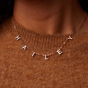 Nahaufnahme der personalisierten Hailey Namenskette in Roségold auf Strickgrund