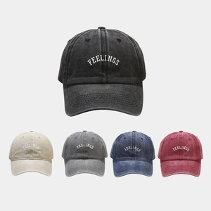 Detailed view of washed cotton baseball caps with FEELINGS embroidery in five colors