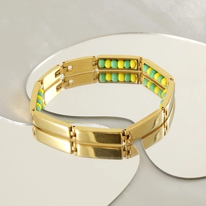 Detailed shot of gold titanium beaded bracelet reflecting on a heart mirror surface