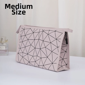 Detail view of a medium-sized pink geometric triangular pattern makeup bag with a zipper