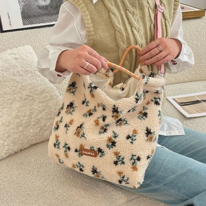 Detail of lamb wool tote bag with floral patterns and orange woven rope handles