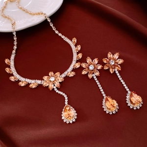 Dettaglio di collana e orecchini con pendenti in zircone su seta rossa elegante