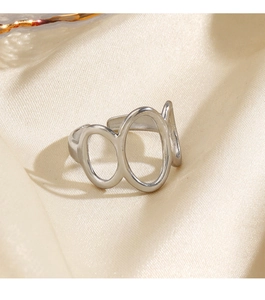 Détail d'une bague ovale géométrique argentée sur un tissu élégant en soie champagne