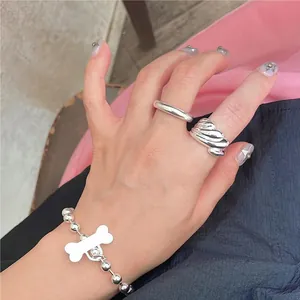 Stackable silver ring set with wavy texture and beaded bracelet with bone pendant charm