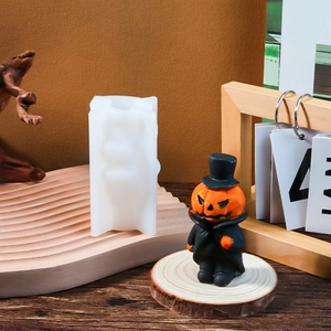 Detail of DIY white silicone pumpkin man mold with a finished orange candle craft