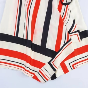 Close-up of geometric striped fabric texture in red, black and white silky material