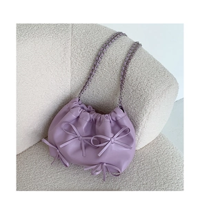Detailed view of purple PU leather bag featuring cute bows and pleated drawstring design