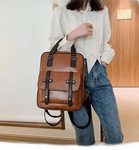 Detailed view of brown faux leather backpack with stylish front pocket and vintage straps