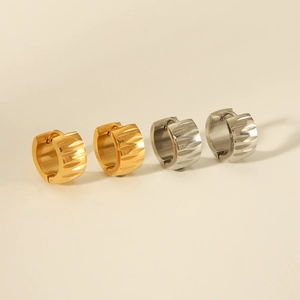 Detail view of gold and silver stainless steel earrings with textured diamond-cut surface