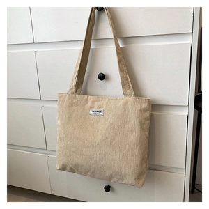 Macro detail of beige corduroy tote bag with fashion label on white drawer