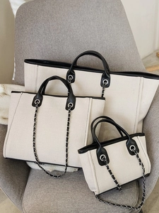 Three-piece set of canvas tote bags with black leather trim and chain shoulder straps