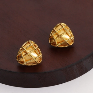 Macro shot of 18K gold plated triangular earrings with brushed texture and woven pattern