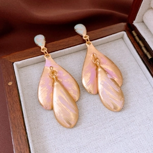 Detailed view of layered leaf earrings with gold plating and colorful hand-painted enamel