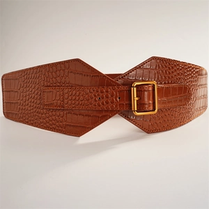 Detail of wide brown faux leather belt with crocodile texture and adjustable gold buckle