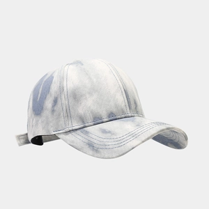 Détail d'une casquette tie-dye en coton bleu et blanc avec visière courbée et boucle