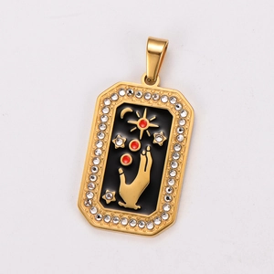 Detailed view of a gold tarot pendant with black enamel, star and moon crystal inlay