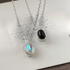 Detailed macro view of 925 sterling silver necklaces with black and blue oval gemstones