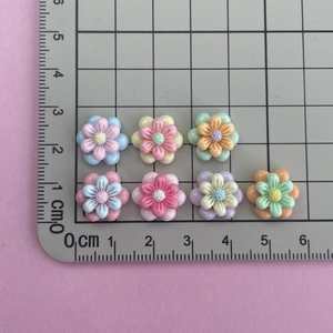 Flat lay of colorful resin flower charms on a measuring mat showing 2cm size detail