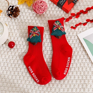 Détail de chaussettes de Noël rouges pour bébés avec sapin 3D et semelle antidérapante