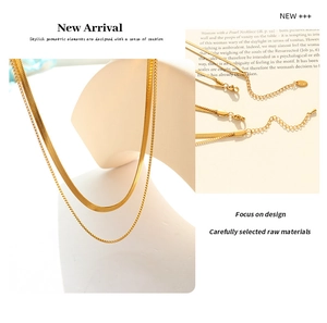 Macro detail of gold layered necklace featuring flat snake chain and delicate box chain