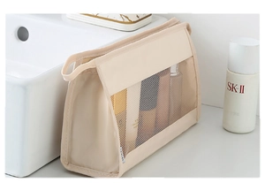 Detailed view of beige mesh travel cosmetic bag showing spacious storage for skincare bottles