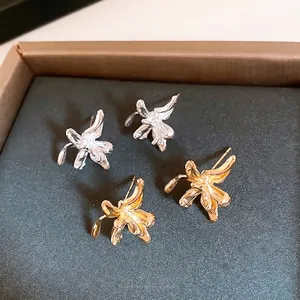 Elegant metal flower stud earrings in gold and silver finish with textured petal details
