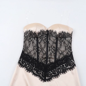 Close-up of champagne satin bodice with black floral lace overlay and corset boning details