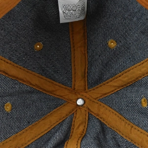 Macro view of interior seams with orange reinforced tape on 100% cotton denim baseball cap
