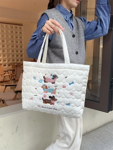 White quilted tote bag with cute cat and heart embroidery shown being held by a woman