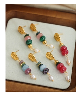 Detailed view of colorful natural stones and freshwater pearls on gold titanium earrings