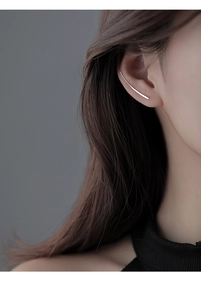 Close-up of a minimalist silver linear ear cuff worn on model's ear cartilage