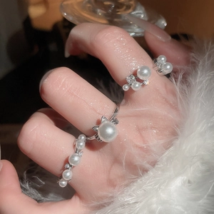 Detailed view of layered S925 silver rings with pearls and zircon in elegant style