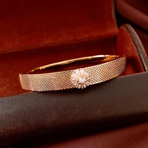 Macro detail of 18K gold-plated mesh bracelet featuring a sparkling zircon flower clasp