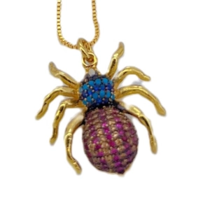 Goldener Spinnenanhänger Halskette mit blauem und rosa Edelsteinbesatz auf Weiß