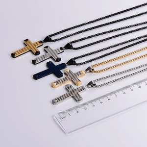 Five stainless steel cross necklaces in various colors displayed with a ruler for size
