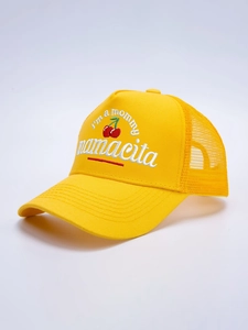 Detail of yellow trucker hat featuring 3D embroidered cherries and mamacita text