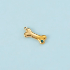 Detail shot of a golden bone pendant featuring a vibrant blue zircon stone inlay
