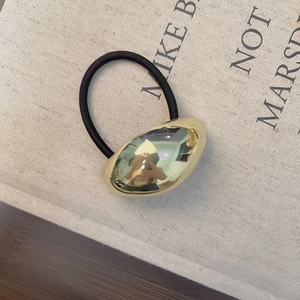 Detail of high-elastic black hair tie with polished irregular gold bean metal piece