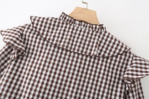 Detail of coffee plaid shirt featuring ruffled stand collar and fabric texture
