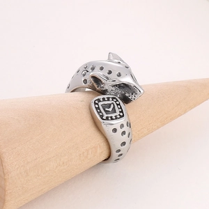 Détail macro d'une bague tête de léopard argentée avec textures noires sur bois