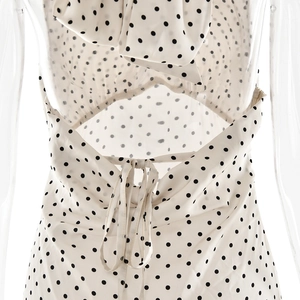 Détail d'une robe blanche à pois avec col licou et dos nu à nouer élégant