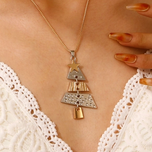 Close-up of a two-tone Christmas tree pendant necklace worn on a lace collar