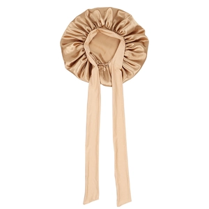 Detailed close-up of champagne satin sleep cap with long adjustable ribbons on white backdrop