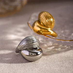 Detail of interlocking gold and silver teardrop rings with sculpted stripe texture