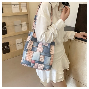 Model wearing a patchwork tote bag featuring pink plaid and denim fabric in a lifestyle setting