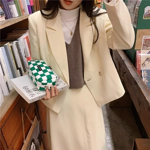 Green and white checkered pencil case held by a person in a minimalist bookstore