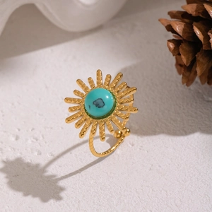 Detail of adjustable gold sunburst ring featuring a centered turquoise stone