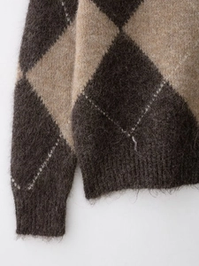 Gros plan sur un tricot à losanges montrant la texture douce en mohair et les bords